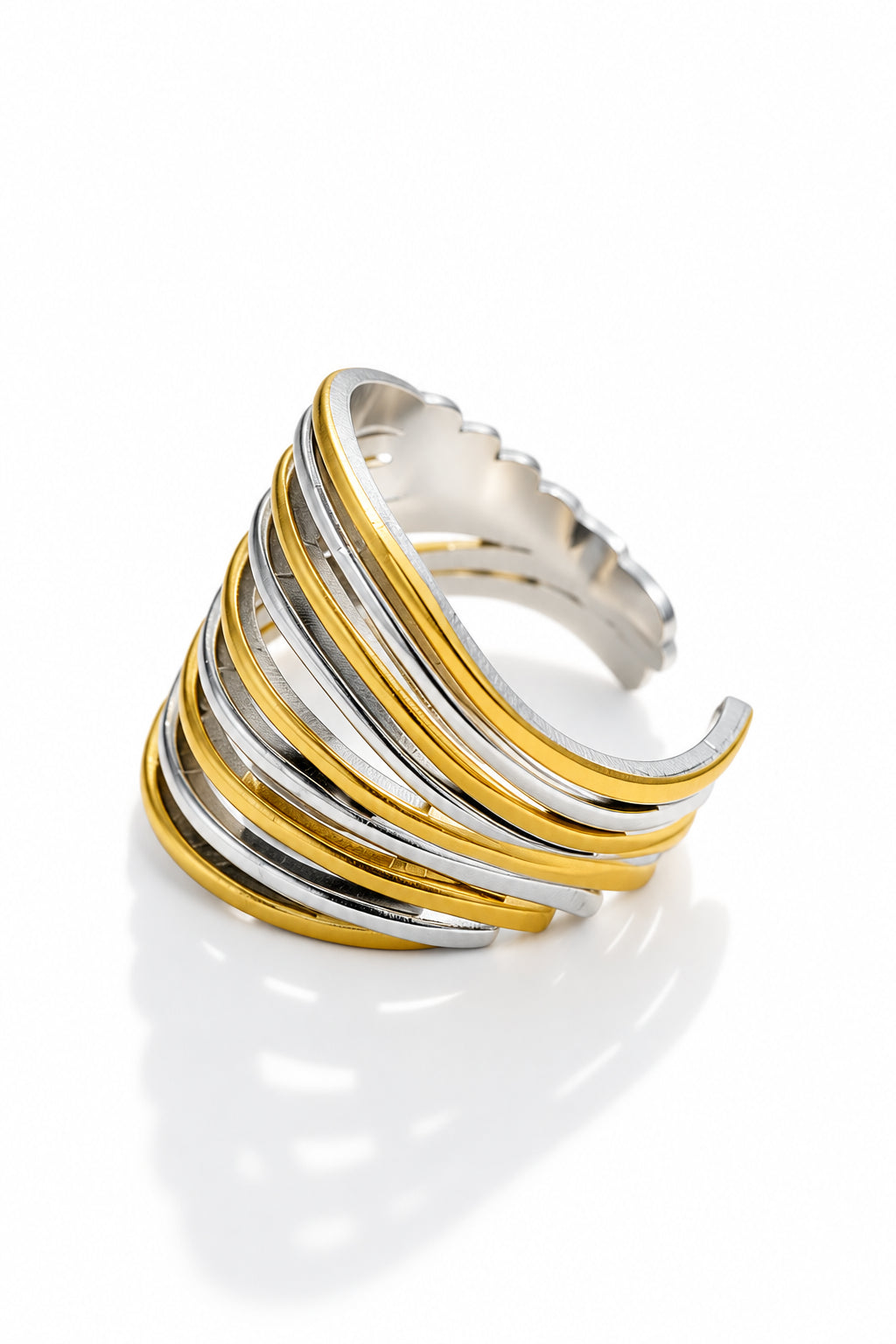 A multi-strand wrap ring featuring alternating polished gold and silver bands, photographed on a clean white surface with soft shadows.